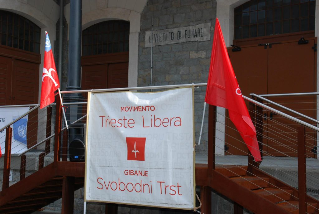 Free Trieste's banner, with two Trieste flags, on the balcony of a storehouse in the Northern Free Port.