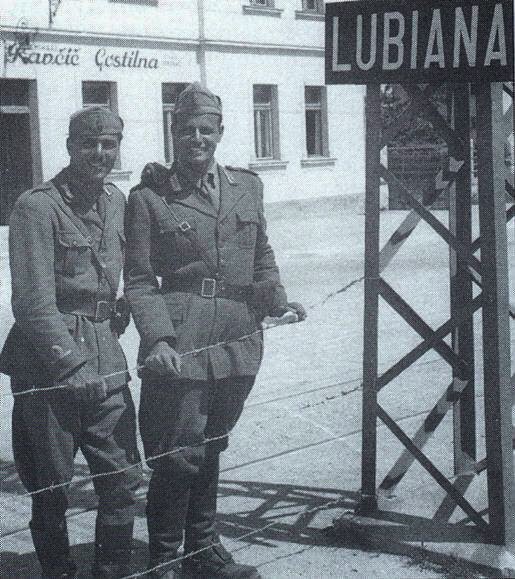 Two Italian soldiers stand next to the barbed wire that encircles Ljubljana, Slovenia, after the Italian invasion of Yugoslavia during WWII (1941). Two Italian soldiers stand next to the barbed wire that encircles Ljubljana, Slovenia, after the Italian invasion of Yugoslavia during WWII (1941).